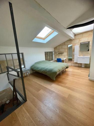 sypialnia z dużym łóżkiem i oknem dachowym w obiekcie Les Capucins w mieście Bordeaux