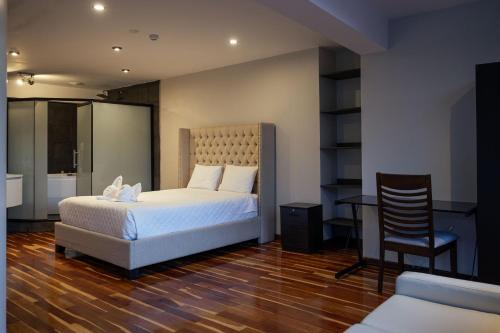 um quarto com uma cama, uma secretária e uma cadeira em Hotel California Urubamba em Urubamba