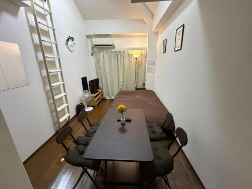 a room with a table and chairs in a room at Guest house TAKAMIYA INN in Fukuoka