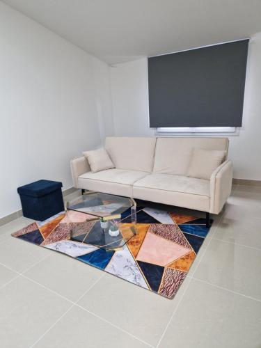 ein Wohnzimmer mit einem Sofa und einem bunten Teppich in der Unterkunft F2 type apartment Near Stade de France in Saint-Denis
