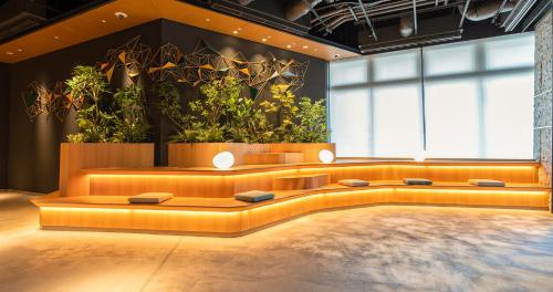 a large room with a couch and some plants at Grids Premium Hotel Kumamoto in Kumamoto