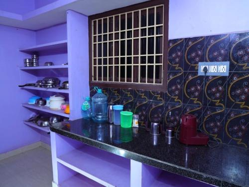 un comptoir dans une cuisine avec un mur avec des assiettes dans l'établissement La nest residency, à Pondichéry