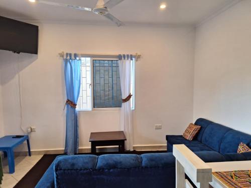 een woonkamer met een blauwe bank en een raam bij Cool breeze in Ukunda