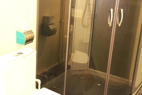 y baño con ducha y puerta de cristal. en Гостевой дом Эверест en Arkit