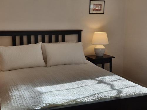 une chambre avec un lit avec une lampe sur une table dans l'établissement Redruth - 2 bedroom cottage situated in wandiligong, à Wandiligong