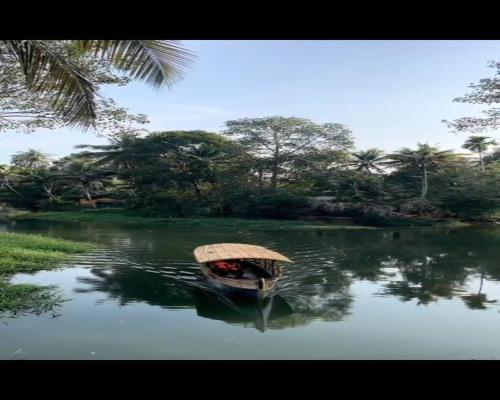 a person in a boat on a body of water at Riverdale Homestay Kumarakom by LexStays in Kumarakom
