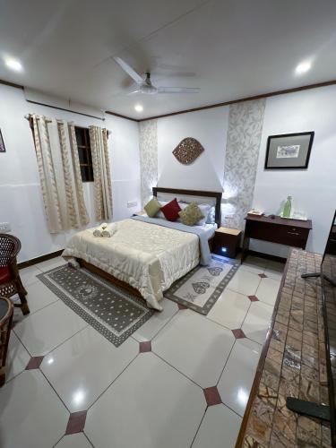 a bedroom with a bed and a table in a room at Riverdale Homestay Kumarakom by LexStays in Kumarakom