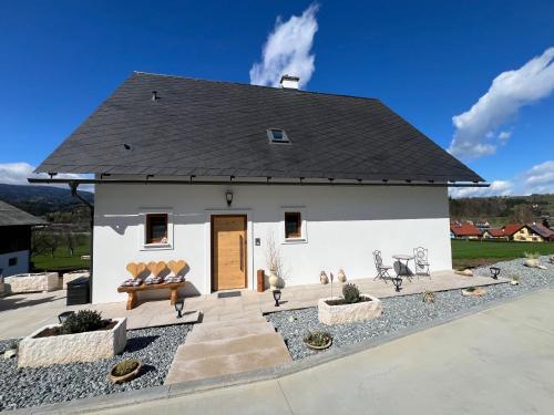 a white house with a black roof at Sonnenschein Appartement- und Ferienhaus mit Terrasse und Garten in Eibiswald