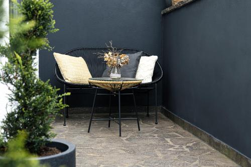 a black chair and a table with a vase of flowers at Idyllische Ferienwohnung im Kraichgau in Sinsheim