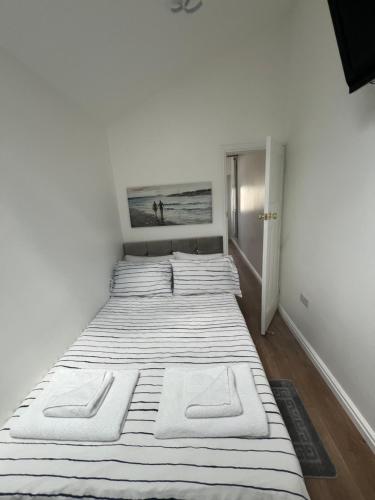 um quarto com 2 camas e paredes brancas em Cosy Studio Apartment, Flat in London em Chislehurst