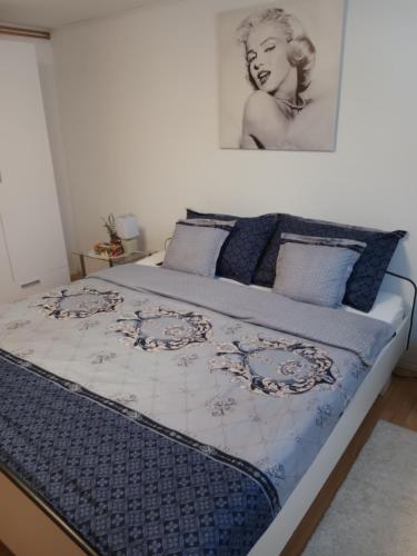 a large bed with a blue and white comforter at PETRA in Ðakovo