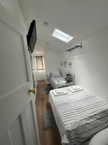 um quarto branco com uma cama e um sofá em Cosy Studio Apartment, Flat in London em Chislehurst