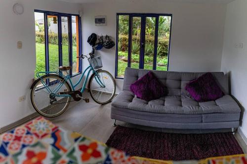 a bike parked next to a couch in a living room at Life is Beautiful! Cottage in the Nature in Pereira