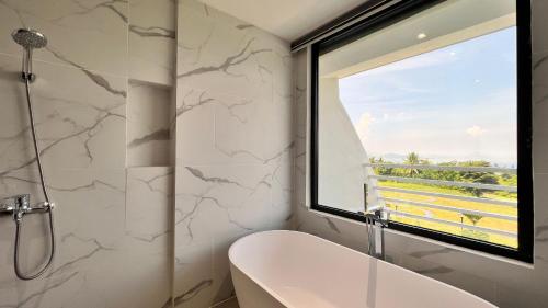 La salle de bains est pourvue d'une baignoire et d'une fenêtre. dans l'établissement The Vineyard at Tanauan, à Tanauan
