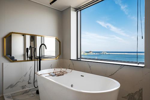 a bath tub in a bathroom with a large window at Stay Hostel in Sokcho