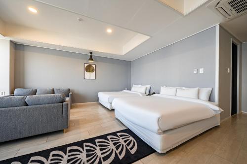 a bedroom with two beds and a couch at Stay Hostel in Sokcho