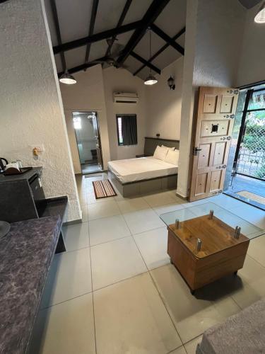 Cette grande chambre comprend un lit et une boîte en bois. dans l'établissement Parnakuti Cottage, à Trimbak