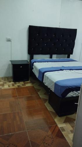 a bedroom with a bed with a black headboard at BOLOGNESI in Huarmey