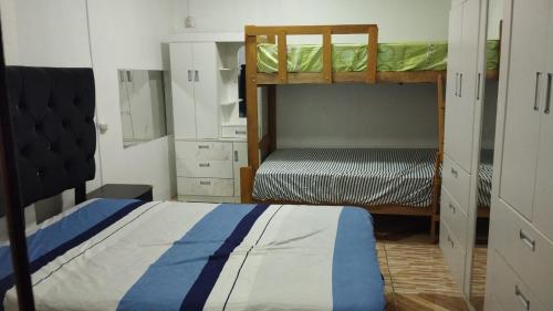a bedroom with two bunk beds and a closet at BOLOGNESI in Huarmey