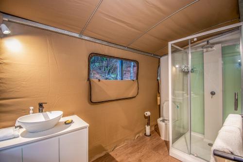 W łazience znajduje się umywalka i prysznic. w obiekcie Deluxe King Safari Tent 2 w mieście Nelly Bay