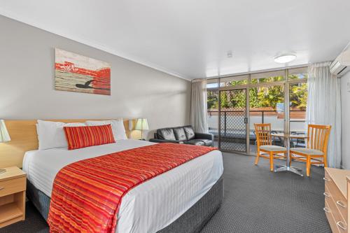 um quarto com uma cama, uma mesa e cadeiras em Comfort Inn Grammar View em Toowoomba