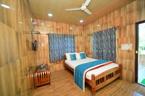 um quarto com uma cama num quarto de madeira em SIPAYI RESORT COORG em Kushālnagar