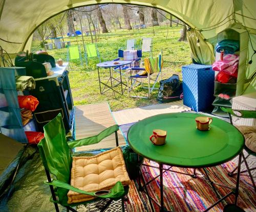 d'une tente avec une table et des chaises vertes. dans l'établissement Kamping Lakoza, à Rrëshen