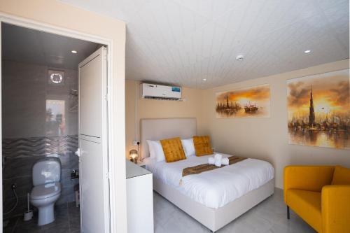 1 dormitorio con cama blanca y baño en Desert Safari Overnight Experience "Modern room with AC & Entertainment", en Hunaywah