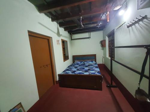 a small bedroom with a bed in a room at Hallimane Homestay in Udupi