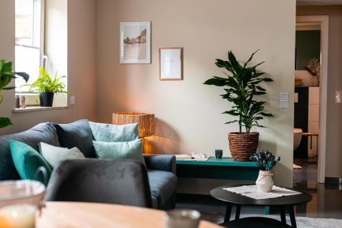 a living room with a blue couch and a potted plant at Idyllische Ferienwohnung im Kraichgau in Sinsheim