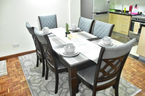 a dining room table and chairs in a kitchen at Wills House, Three Bedroom with Extra Bed in Kilimani in Nairobi