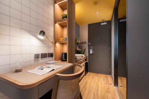uma cozinha com uma secretária e cadeiras num quarto em Dash Living on Hollywood em Hong Kong