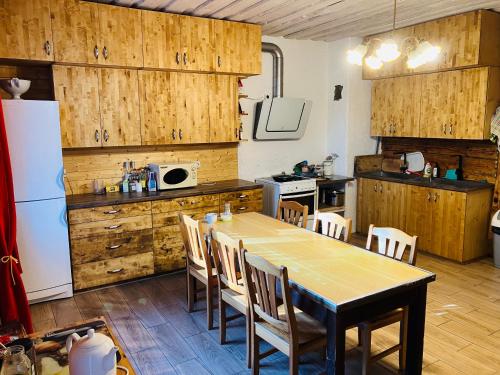 uma cozinha com uma mesa e cadeiras e um frigorífico em Kahene tuba em Tapa