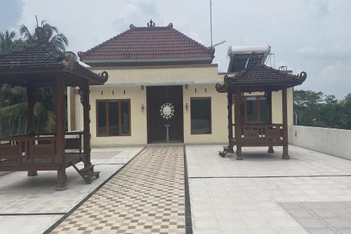 a house with two gazebos in front of it at GB 2 Backpacker Borobudur in Sekatonan