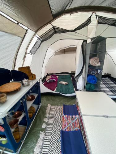 a tent with a bed and a table in it at Kamping Lakoza in Rrëshen