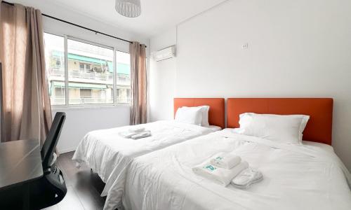 two twin beds in a room with a window at ANhome K11 serviced apartments Plus in Athens