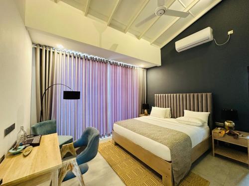 a hotel room with a bed and a desk and a bed sidx sidx sidx sidx at The Niche Hikkaduwa - 10 minutes to the beach in Hikkaduwa