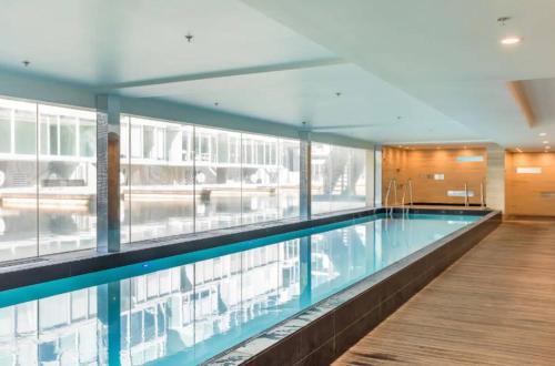 a large swimming pool in a building with windows at Lovely 2 bedrm apartment in Auckland's viaduct in Auckland