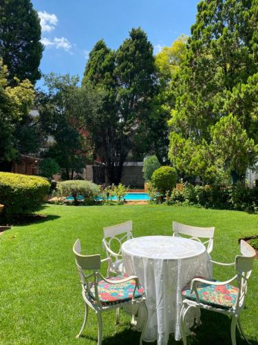 a white table and chairs in a yard at Garden Court in Potchefstroom