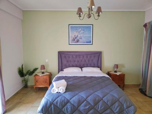 a bedroom with a purple bed with two white towels on it at Athevillas Antonis in Mína
