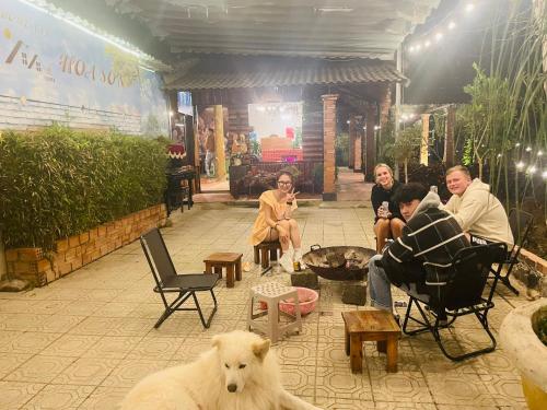 a group of people sitting around a fire with a dog at Hoa Son Village Da Lat in Xuan An
