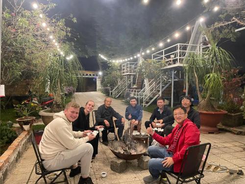 a group of people sitting around a table in a garden at Hoa Son Village Da Lat in Xuan An