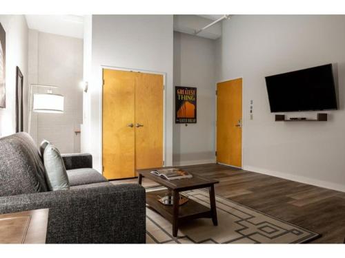 a living room with a couch and a tv at Beautiful 2BR 2BA In The Block by CozySuites in Indianapolis