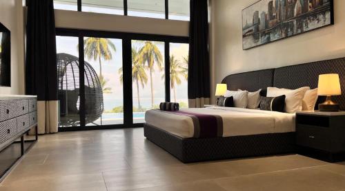 una camera con un grande letto e vista sull'oceano di The Vineyard at Tanauan a Tanauan