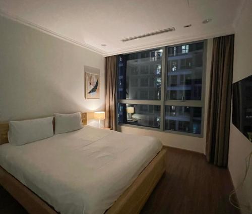 um quarto com uma cama grande e uma janela em Vinhomes Landmark Apartment - CirillaHome em Cidade de Ho Chi Minh