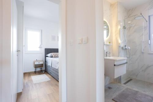 une salle de bain avec une douche et un lavabo et un lit dans l'établissement La Petite, à Trogir
