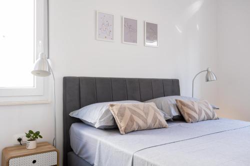 - une chambre blanche avec un lit et deux oreillers dans l'établissement La Petite, à Trogir