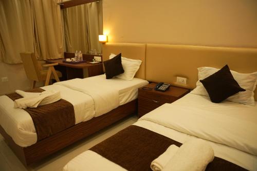 Hotel Mystic Mithila في جاناكبور: غرفة فندقية بسريرين وطاولة