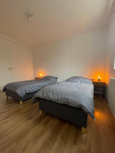 a bedroom with two beds and two lights on the wall at AlleeStudio: ruhig und zentral in Essen