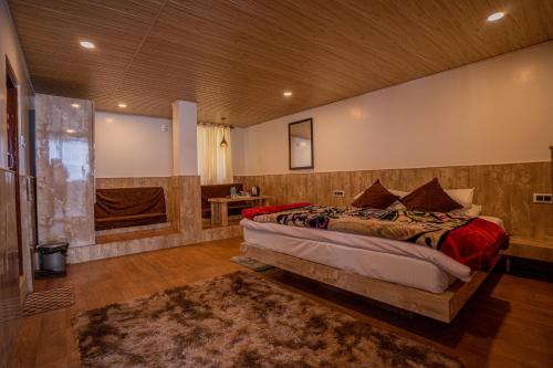 a bedroom with a large bed and a bathroom at Darjeeling Guest House Deluxe in Darjeeling